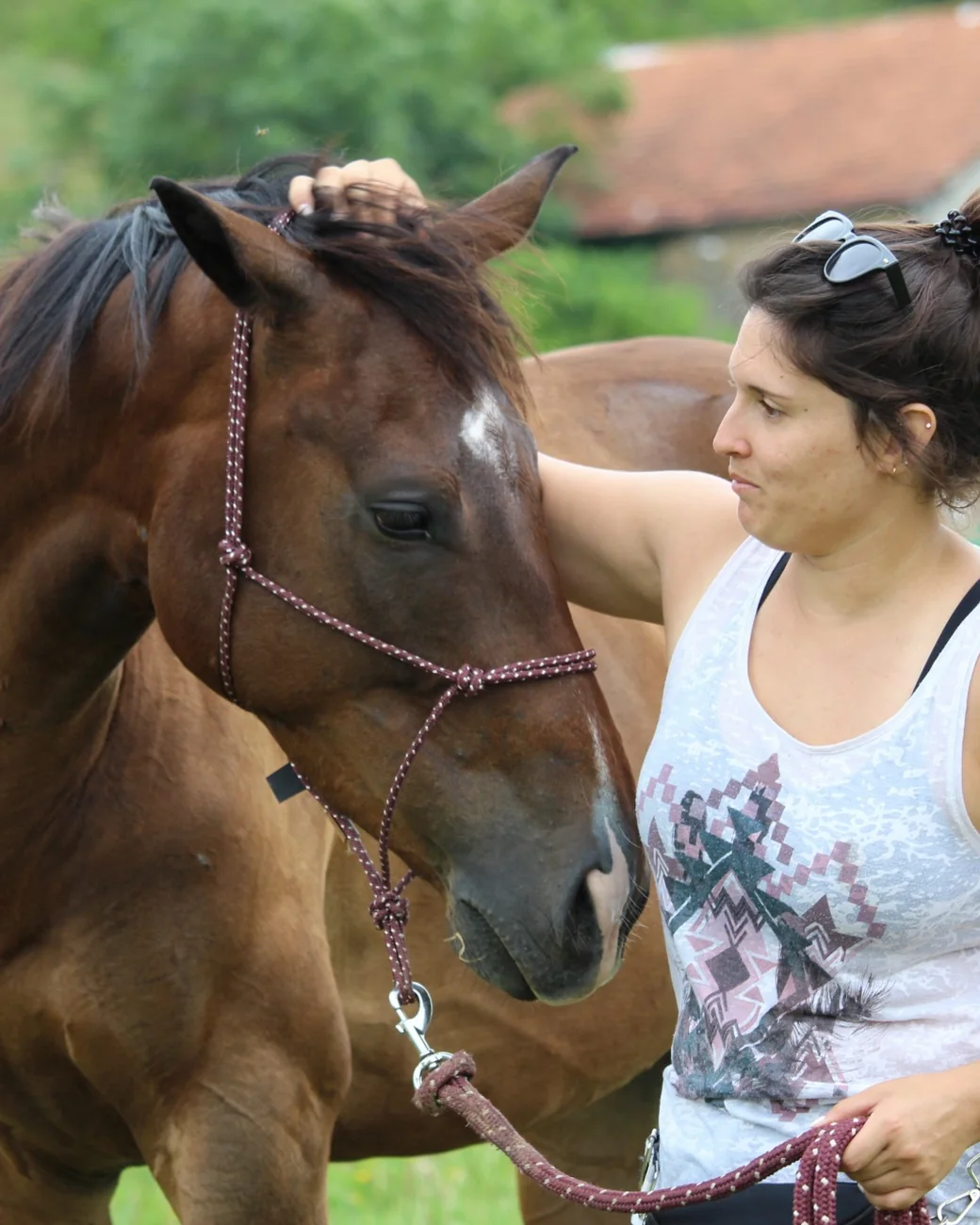 Pauline pose sa main sur le toupet du cheval, la tête tournée vers elle